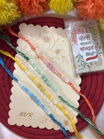 NVR Set of 4 Multicolor Artificial Beads Thread Rakhi with Roli Chawal Chandan Mishri